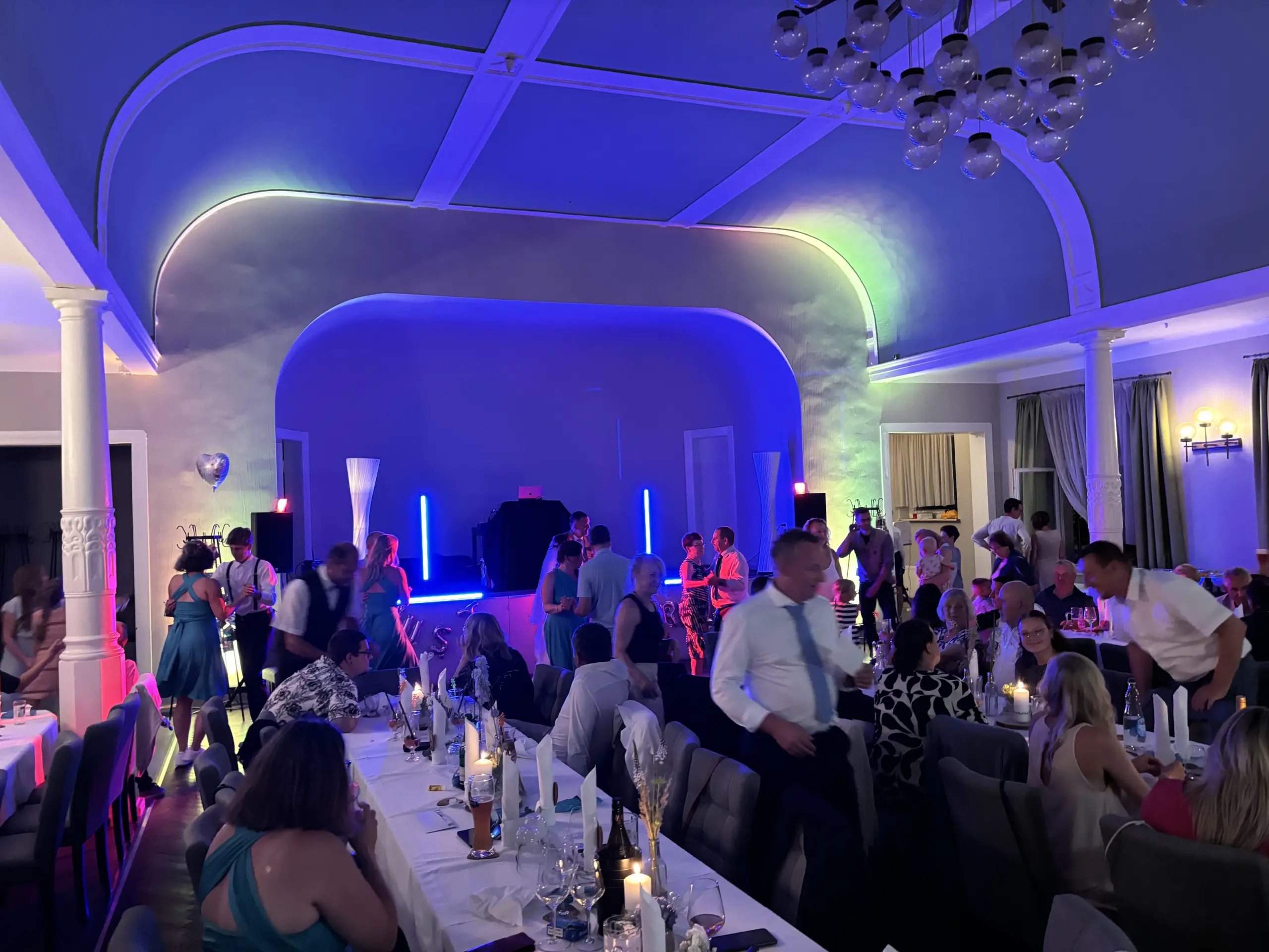Ballsaal vom Gasthof Lindenthal in dem eine Hochzeitsfeier mit DJ ist und die Gäste tanzen.
